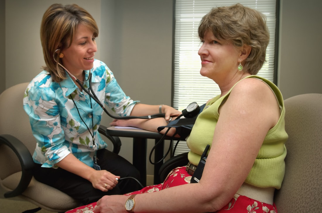 A patient and their doctor smiling together during a friendly checkup