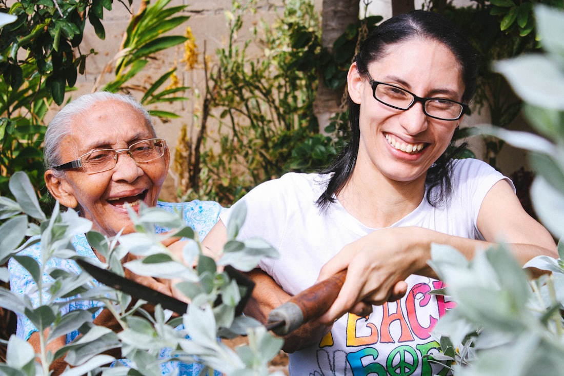 An adult child and their aging parent laughing together outdoors