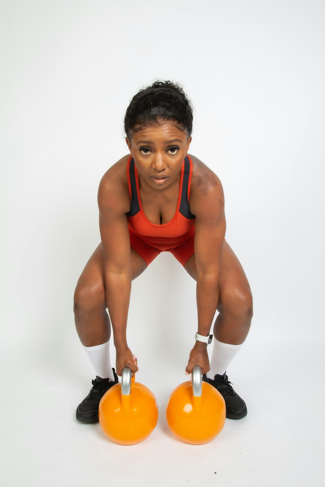 Woman strength training with kettlebells, smartwatch on wrist